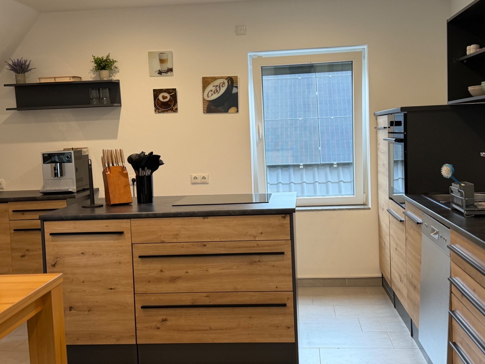 Gereinigte Küche mit Holzfronten und Essbereich in einer Dachgeschosswohnung